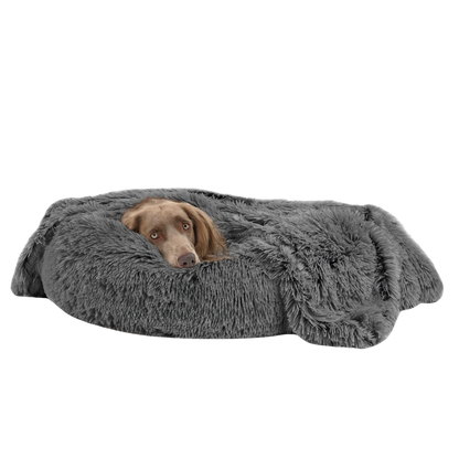 Dog lying on a fluffy gray pet bed against a white background